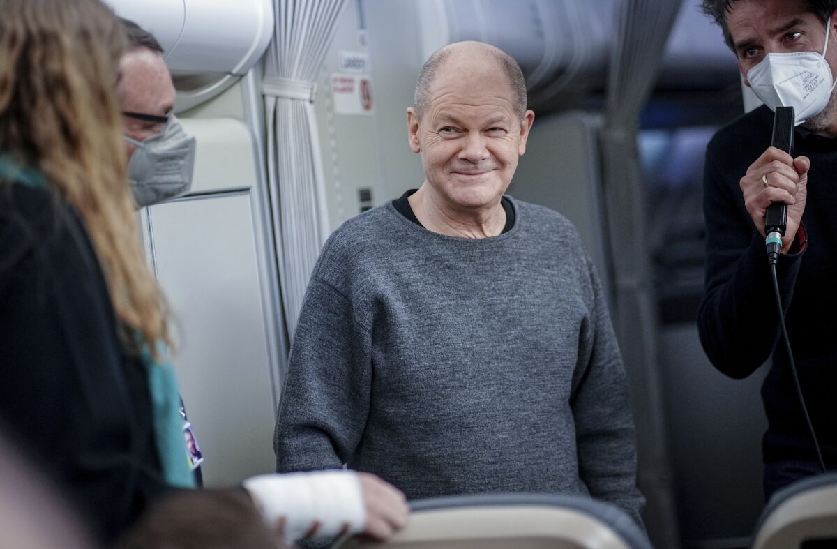 German Chancellor Olaf Scholz smiles during a briefing for journalist on a government plane on the way to Washington for a meeting with United States President Joe Biden, at the airport Schönefeld near Berlin, Germany, Sunday, Feb. 6, 2022. German Chancellor Olaf Scholz planning to travel to Ukraine and Russia on Monday, Feb. 14, 2022, in an effort to help defuse escalating tensions as Western intelligence officials warn that a Russian invasion of Ukraine is increasingly imminent. (Kay Nietfeld/dpa via AP)