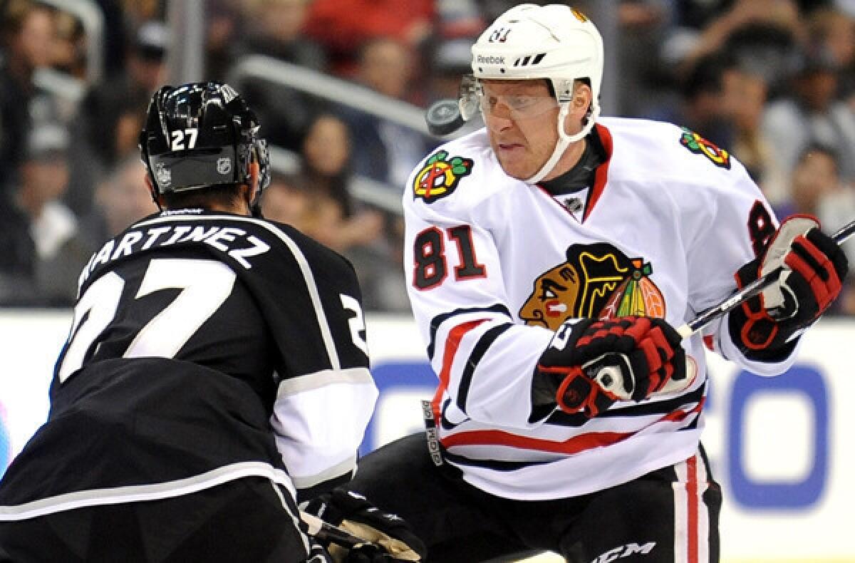 Kings defenseman Alec Martinez and Blackhawks winger Marian Hossa battle for the puck during a regular-season game this season at Staples Center.