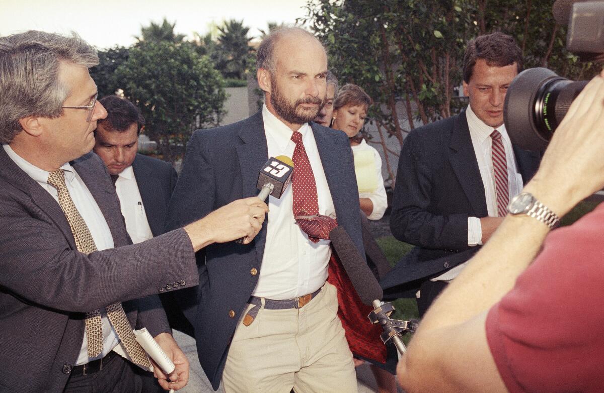 FILE - Former Exxon Valdez Capt. Joseph Hazelwood is surrounded by reporters as he leaves his re-licensing hearing in Long Beach, Calif., on July 25, 1990. Hazelwood, the captain of the Exxon Valdez oil tanker that ran aground more than three decades ago in Alaska, causing one of the worst oil spills in U.S. history, has died in July 2022, the New York Times reported. He was 75. (AP Photo/Alan Greth, File)