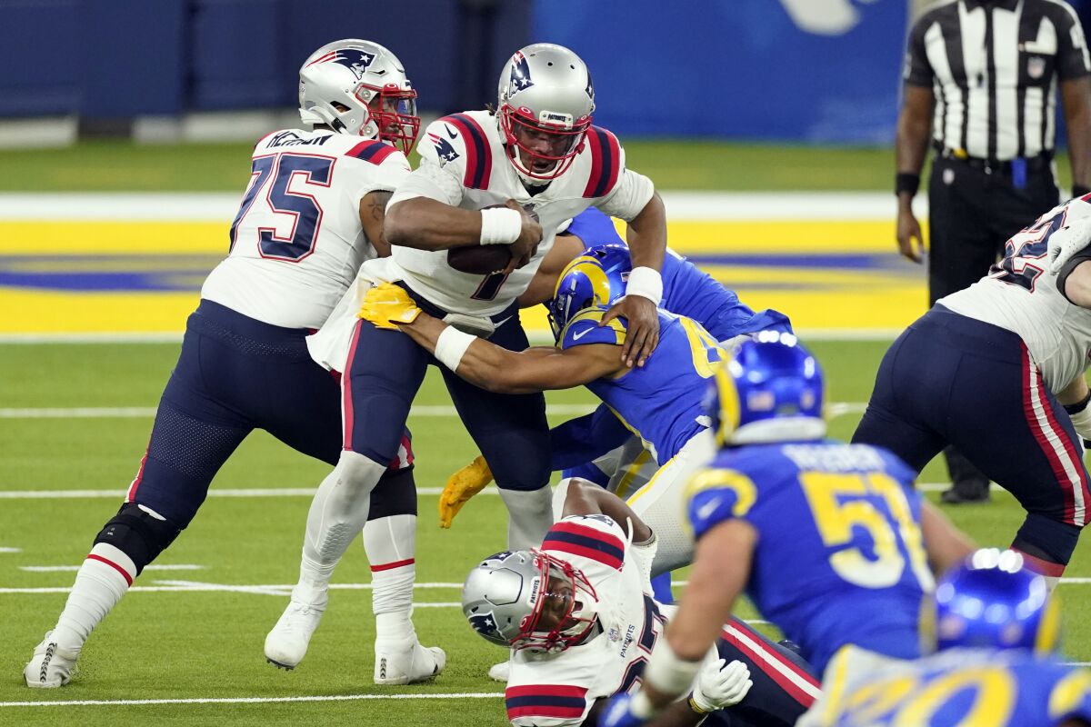 New England Patriots quarterback Cam Newton, center, is sacked by Los Angeles Rams linebacker Kenny Young during the second half of an NFL football game Thursday, Dec. 10, 2020, in Inglewood, Calif. (AP Photo/Ashley Landis)