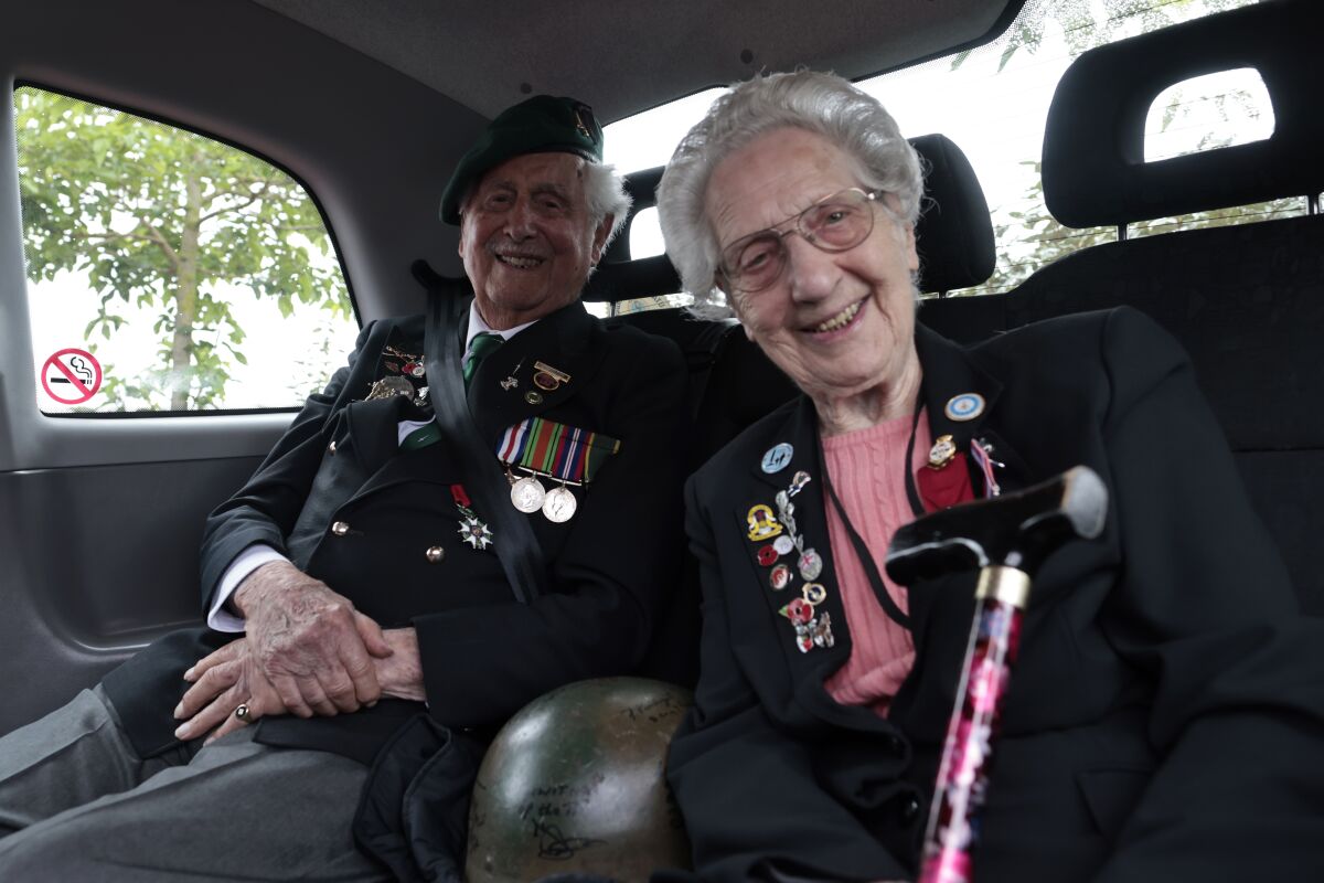 British veterans Roy Maxwell and Mary Scott arrive in a British Taxi Charity for Military Veterans to the ceremony at Pegasus Bridge, in Ranville, Normandy, Sunday, June, 5, 2022. On Monday, the Normandy American Cemetery and Memorial, home to the gravesites of 9,386 who died fighting on D-Day and in the operations that followed, will host U.S. veterans and thousands of visitors in its first major public ceremony since 2019. (AP Photo/Jeremias Gonzalez)