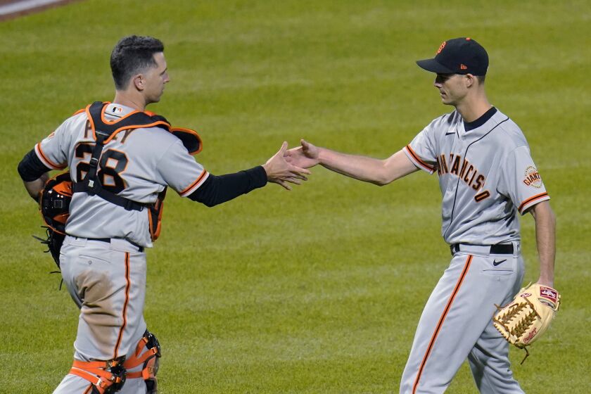 San Francisco Giants relief pitcher Tyler Rogers, right, shakes hands with catcher Buster Posey after the team's 3-1 win over the Pittsburgh Pirates in a baseball game in Pittsburgh, Thursday, May 13, 2021. (AP Photo/Gene J. Puskar)