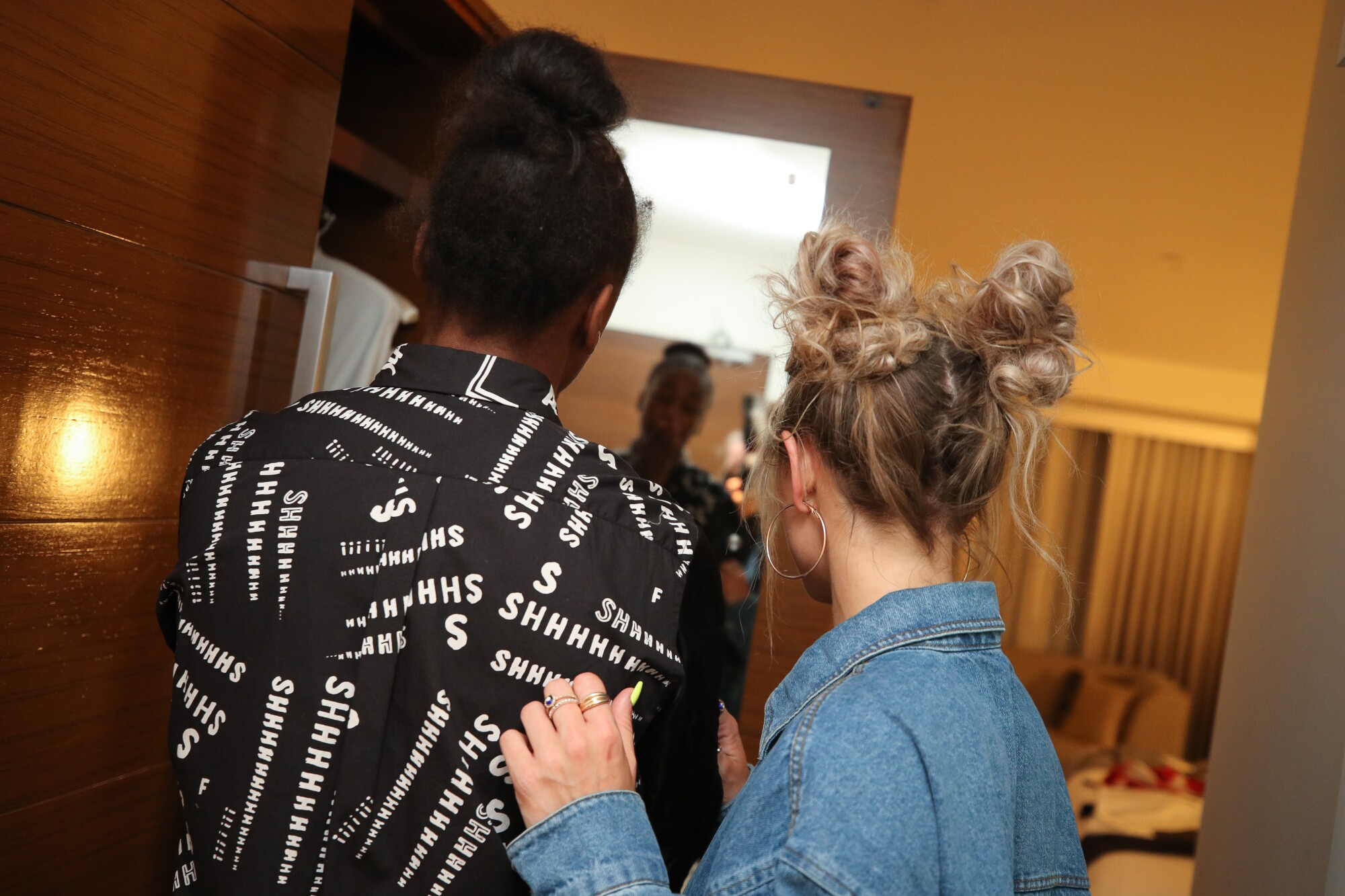 Jewell Loyd and stylist Sydney Bordonaro check out a shirt in the mirror.