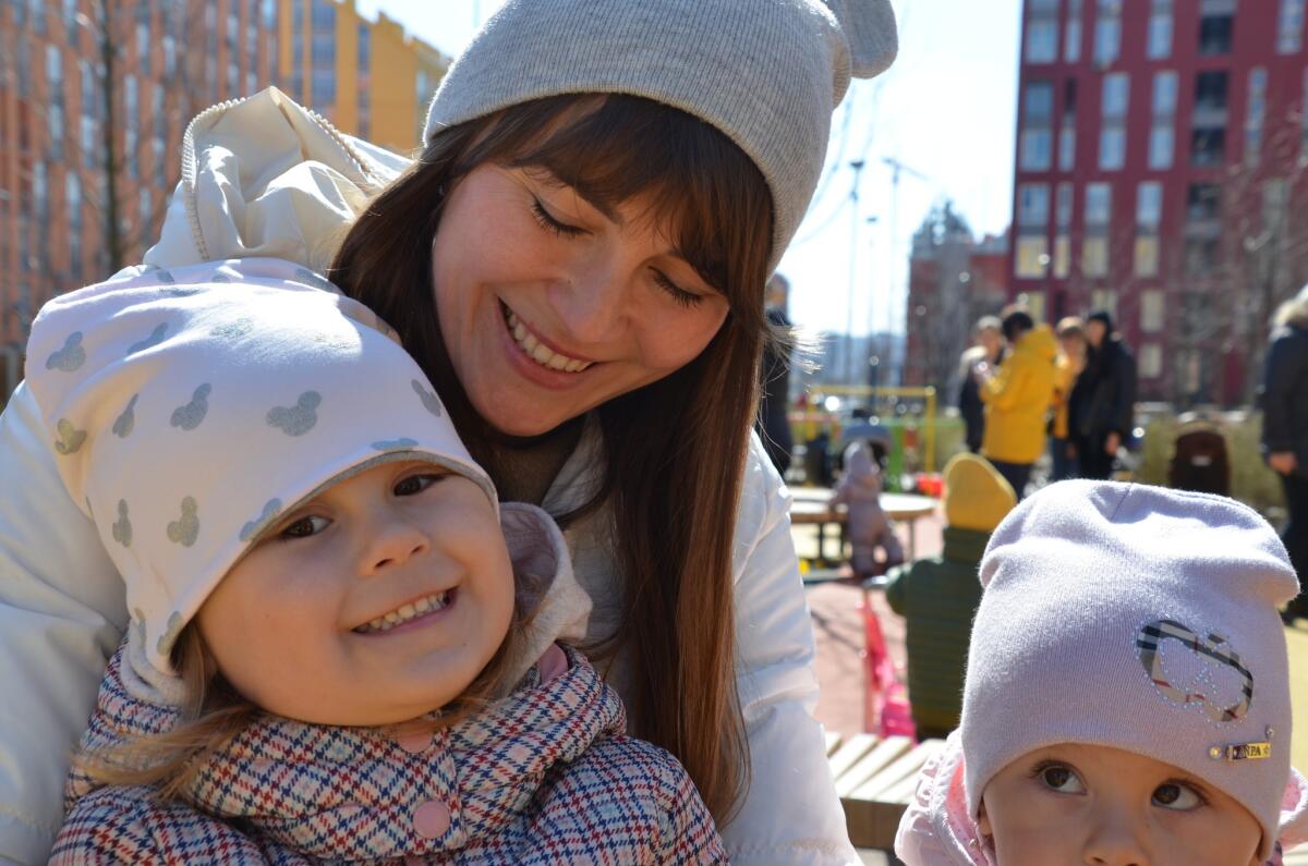 Comfort Town resident Natasha Kalnibolotskaya and her daughters, Masha, left, and Vera, at a playground in the housing complex.