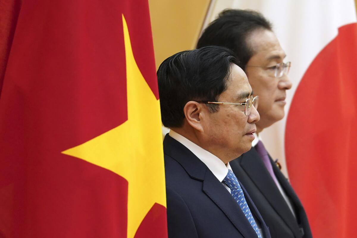 Vietnam's Prime Minister Pham Minh Chinh, left, and Japan's Prime Minister Fumio Kishida, review an honor guard ahead of a meeting at the prime minister's official residence in Tokyo, Japan, on Wednesday, Nov. 24, 2021.(Toru Hanai/Pool Photo via AP)