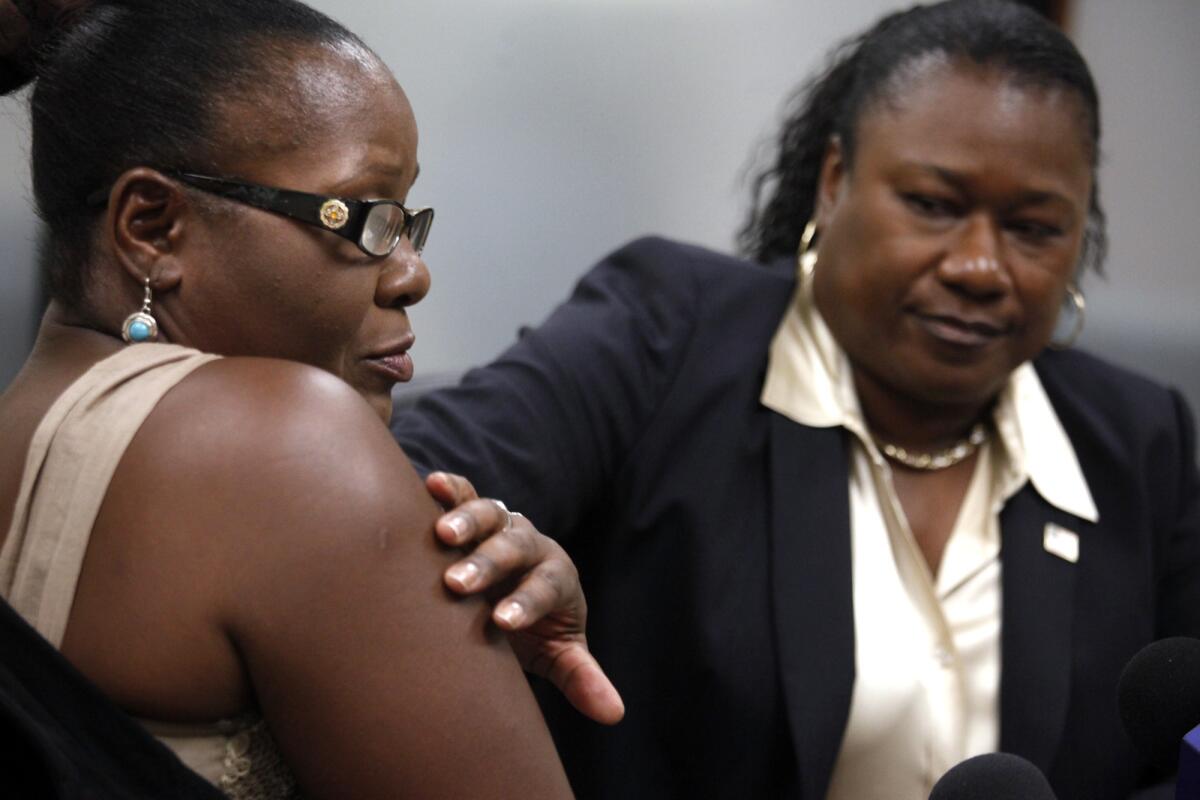 Attorney Caree Harper, right, runs her hand over a lump that's visible on Marlene Pinnock's arm that they said came from a beating by a CHP officer in August.