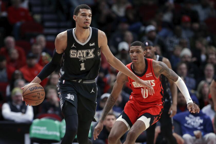 San Antonio Spurs center Victor Wembanyama (1) brings the ball down court in front of Houston Rockets forward Jabari Smith Jr. (10) during the second half of an NBA basketball game Monday, Dec. 11, 2023, in Houston. (AP Photo/Michael Wyke)