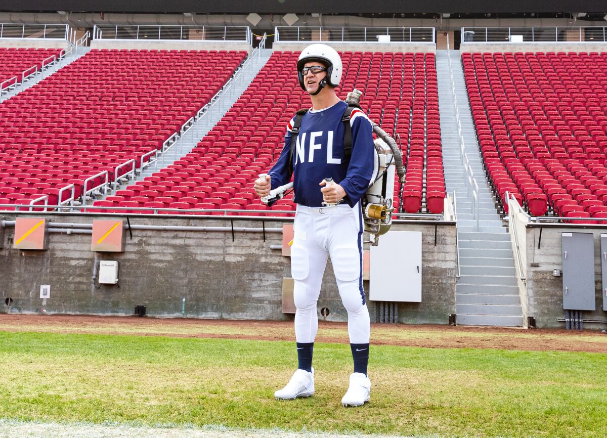 Peyton Manning wears a jet pack to simulate a portion of the Super Bowl I halftime show.