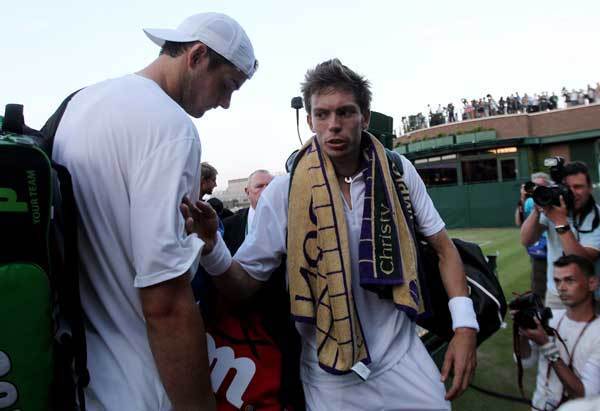 John Isner (L) and Nicolas Mahut prepare to leave court 18 as light stops play at 59-59 in the last set on Day Three of the Wimbledon Tennis Championships on June 23, 2010. The game has become the longest in Grand Slam history.