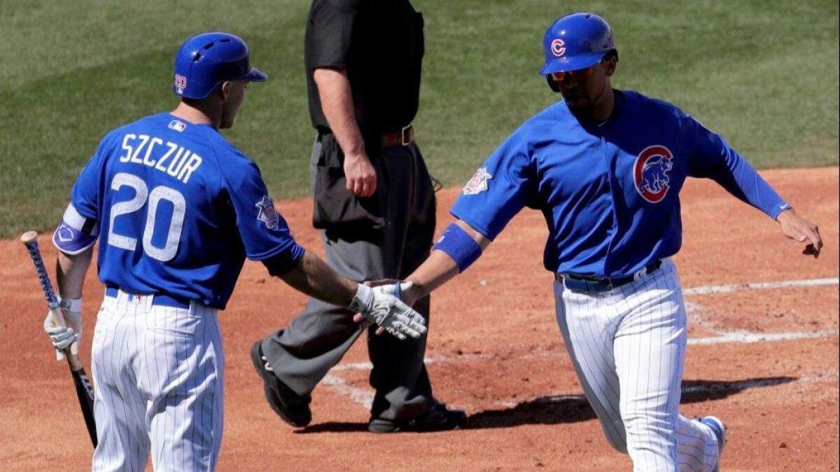 The Cubs' Jon Jay greets Matt Szczur after scoring against the Dodgers during Saturday's spring-training game.