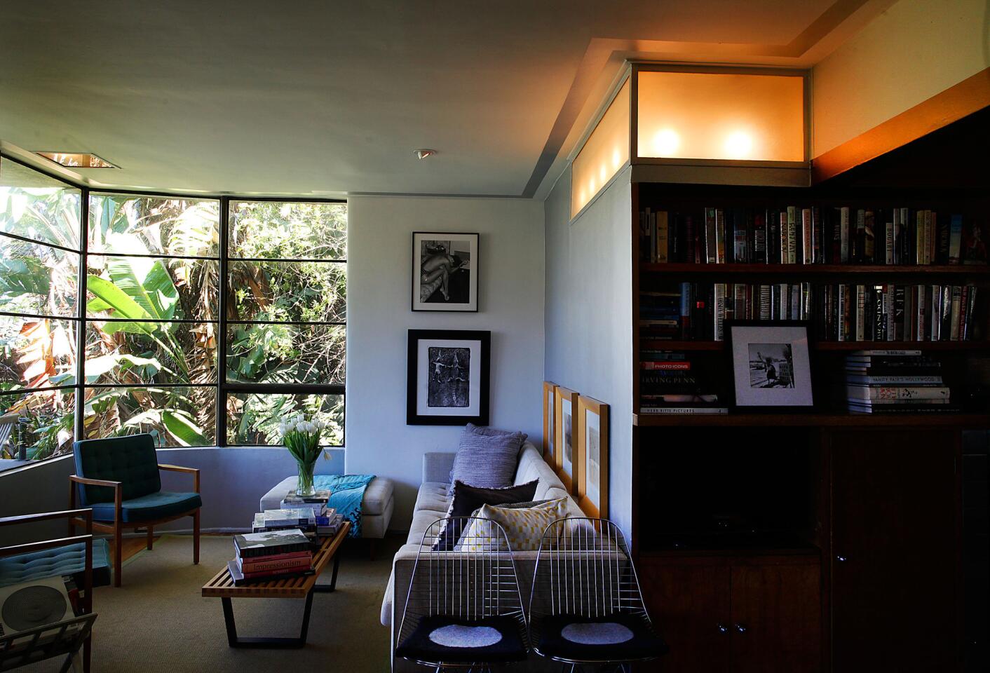 The curving lines of the window are just the first of William Kesling's Streamline Moderne elements in Jay Huguley's house. Huguley chose not to hang curtains, favoring garden views and light over privacy. Note the built-in light box above the bookcase.