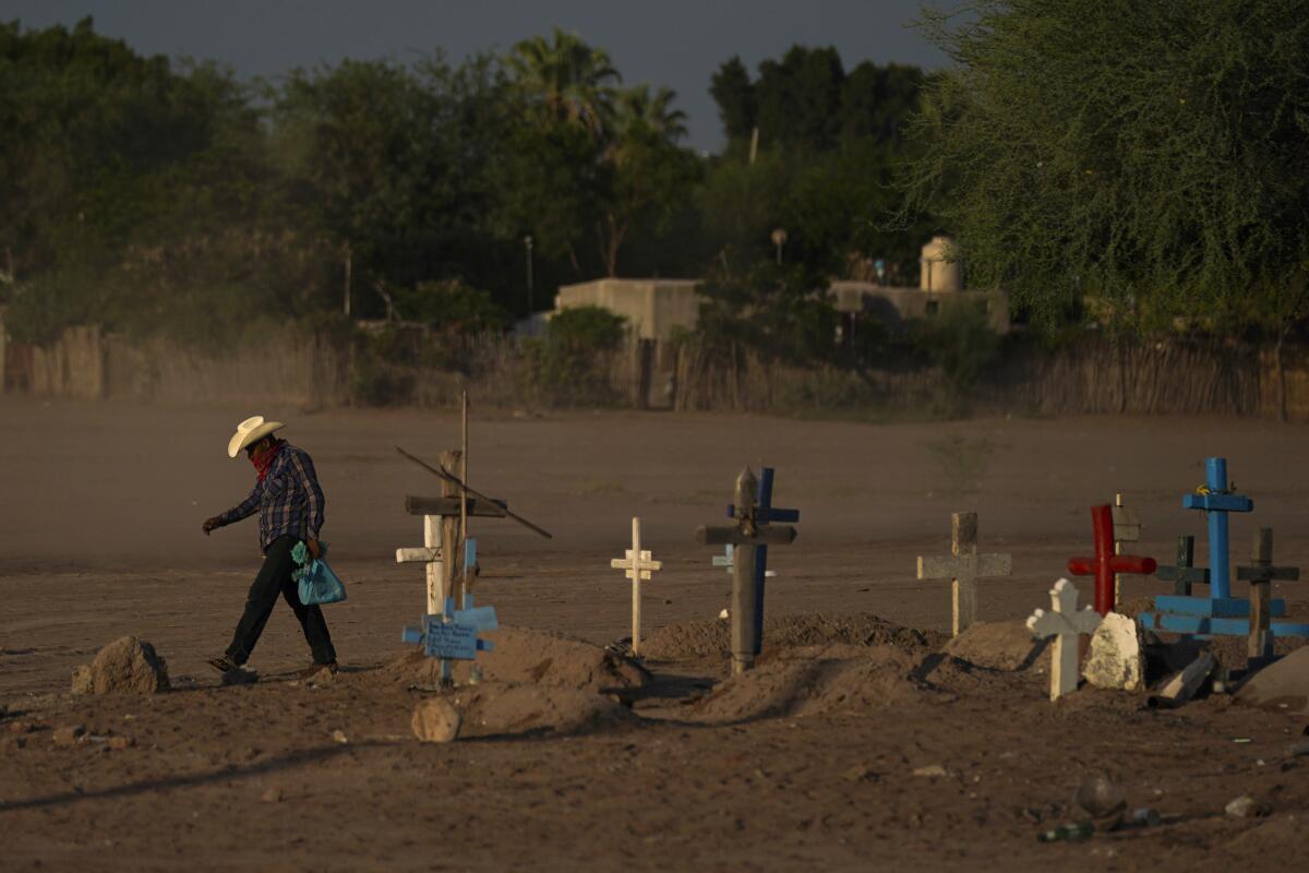 Un indígena yaquí cruza entre el polvo, el martes 27 de septiembre de 2022, un cementerio