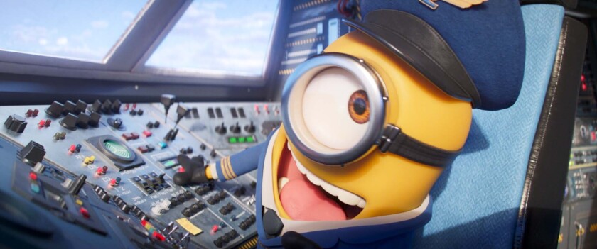 A yellow Minion in a pilot suit sits in an airplane's cockpit