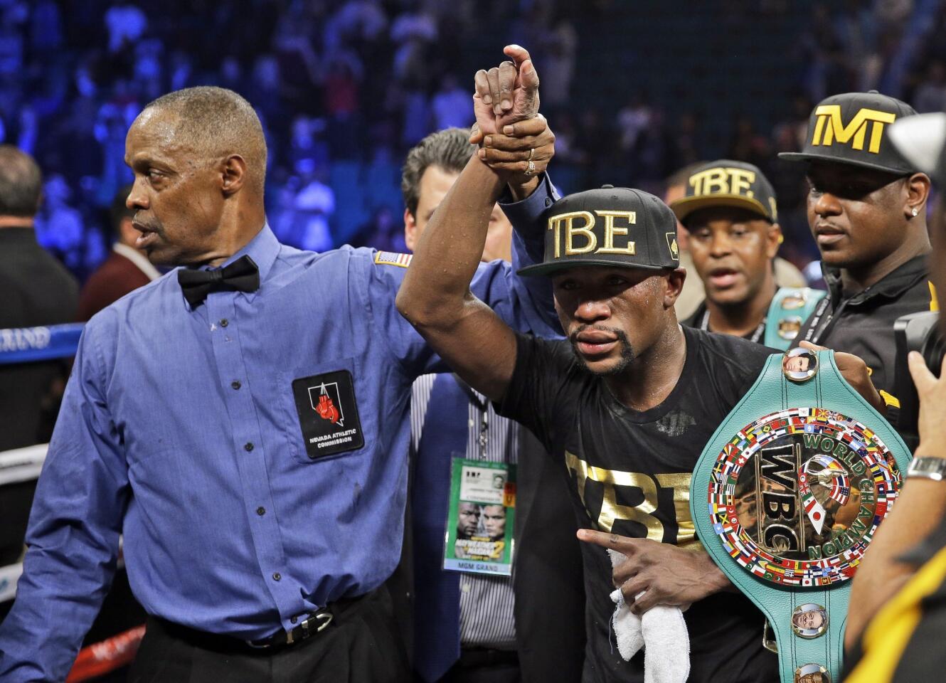 Referee Kenny Bayless raises the right hand of Floyd Mayweather Jr. after he defeated Marcos Maidana by unanimous decision on Saturday night in the world welterweight title fight.