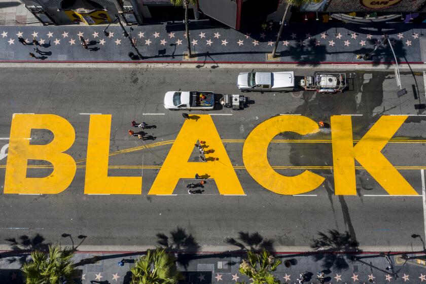 Hollywood, CA, Monday, June 15 2020 - Crews begin to erase the All Black Lives Matter sign painted on Hollywood Blvd., across from the Hollywood and Highland complex. (Robert Gauthier / Los Angeles Times)