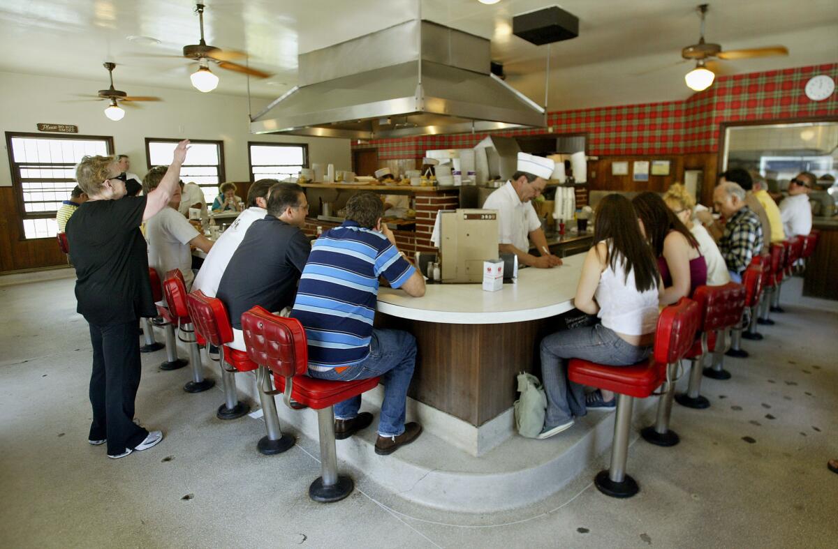 The busy counter at The Apple Pan on Pico Blvd. dates from 1949, and serves nothing but burgers, sandwiches and pies. (Ricardo DeAratanha / Los Angeles Times)