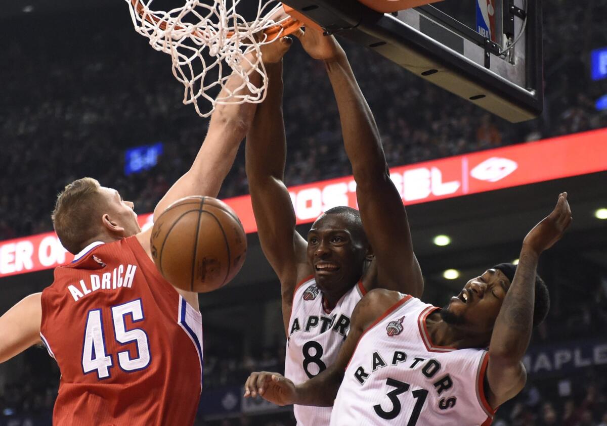 Raptors center Bismack Biyombo slams a dunk over Clippers center Cole Aldrich's block attempt during first half.