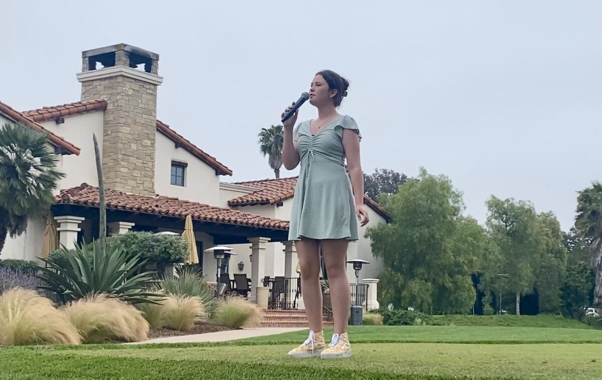 Olivia Markey sings "The National Anthem" at the RSF Golf Club.