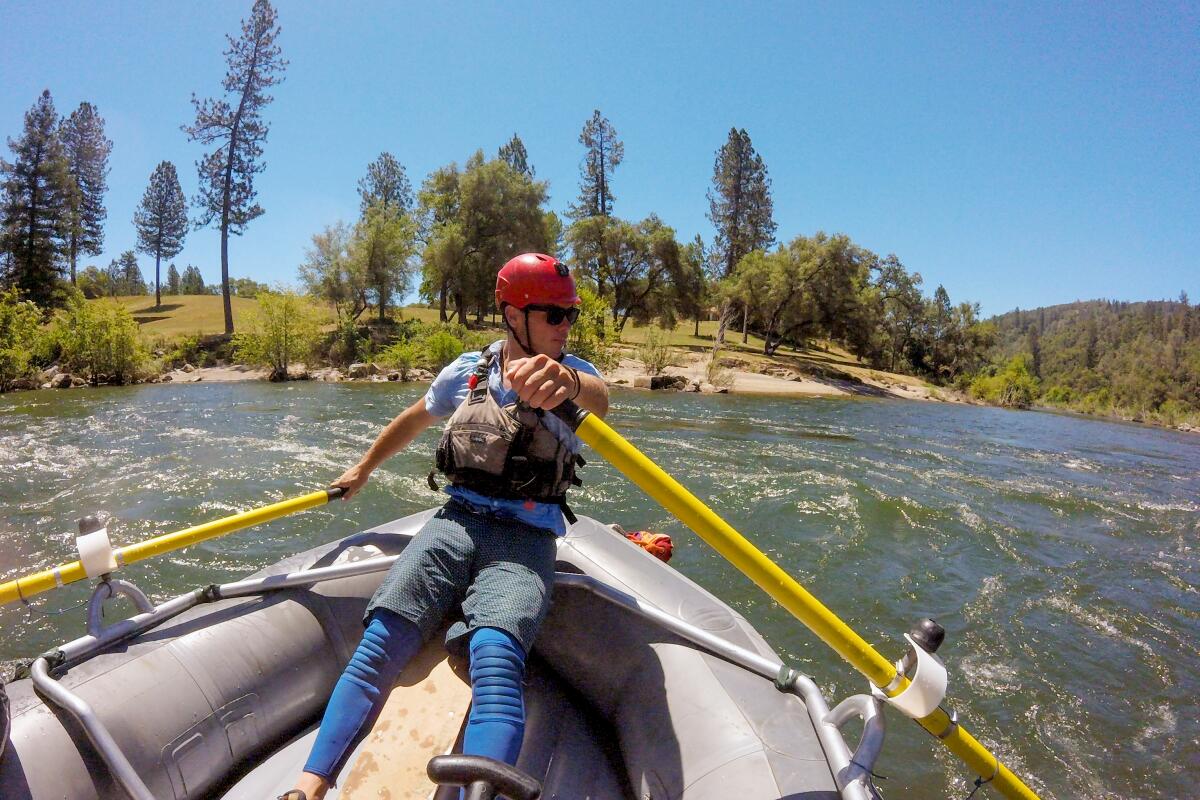 A river guide rows a raft on the South Fork of the American River.