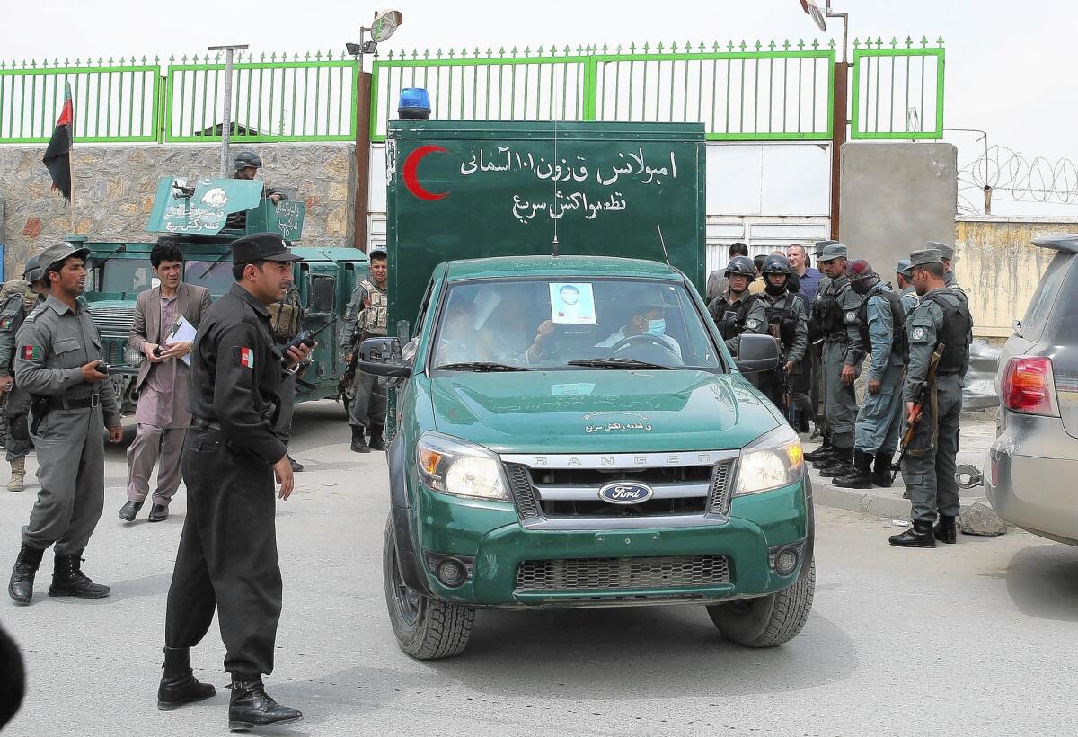 An Afghan police ambulance leaves the CURE International hospital in Kabul, where a gunman killed three Americans.