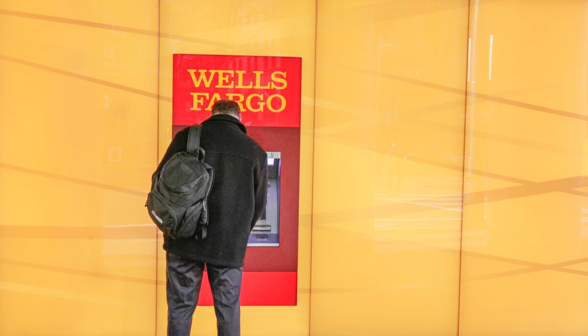 A customer uses an ATM outside a Wells Fargo branch bank