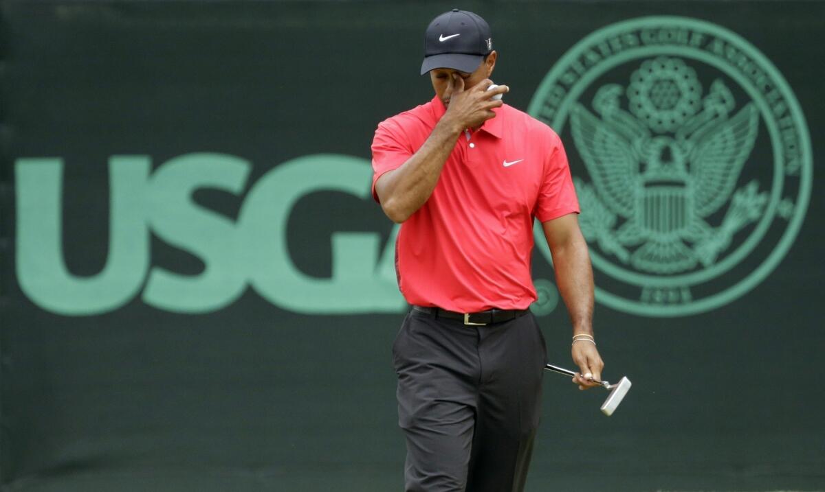 Tiger Woods reacts after putting on the eighth green during the fourth round of the U.S. Open at Merion Golf Club in Ardmore, Pa.