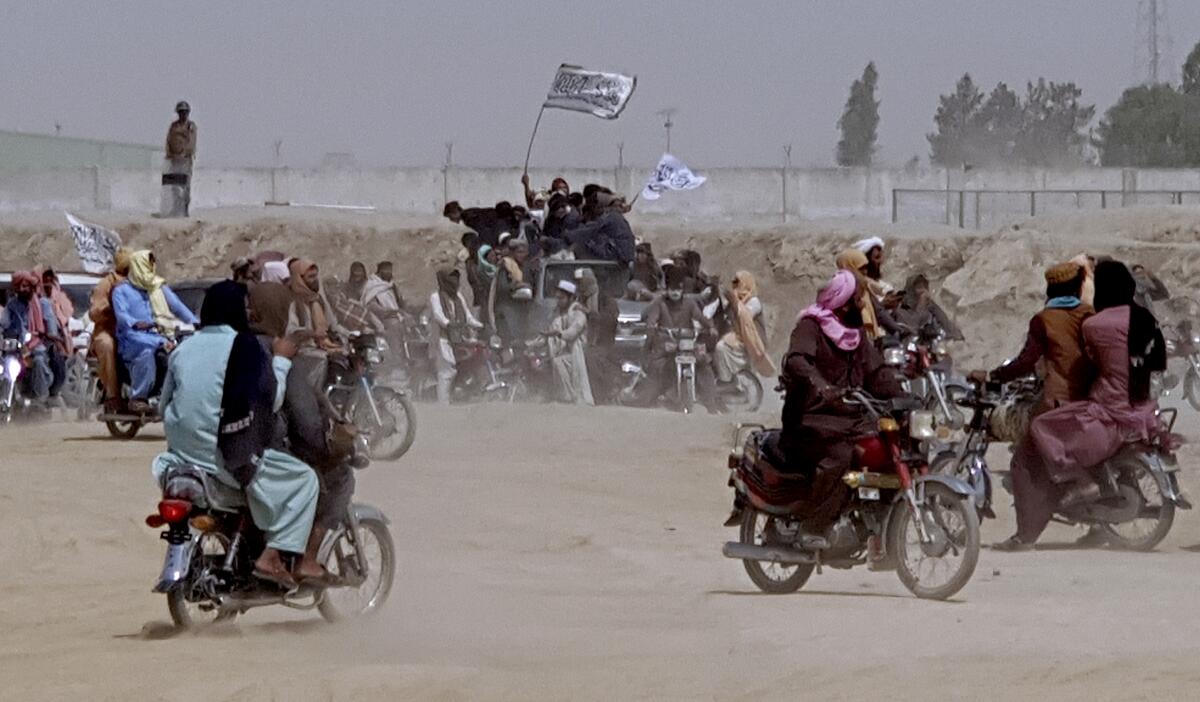 People on motorbikes gather, some holding flags