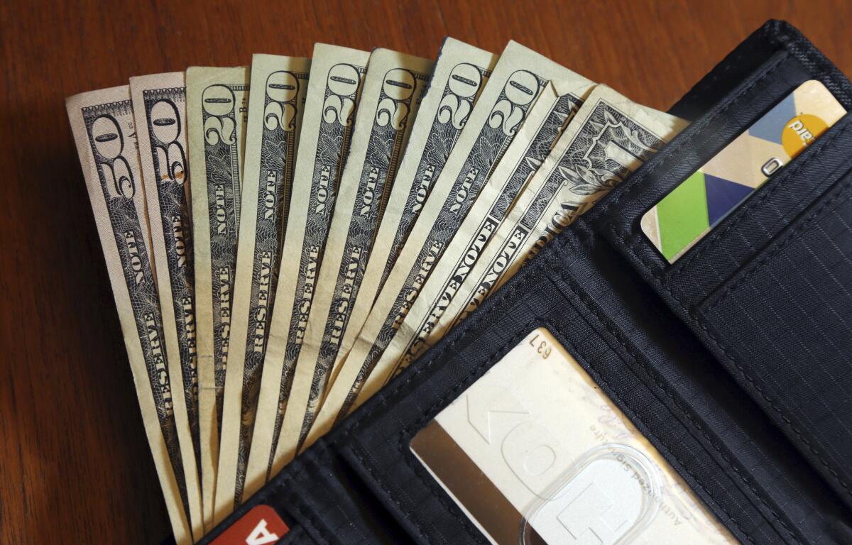 FILE - In this June 15, 2018, file photo, cash is fanned out from a wallet in North Andover, Mass. Using a financial adviser for your investment needs is 100% on brand, but what about all the other parts of your retirement life? A third of people ages 64 and up have a financial adviser, but only 2% asked their adviser to help with their Medicare choices, according to a July 2022 report. (AP Photo/Elise Amendola, File)