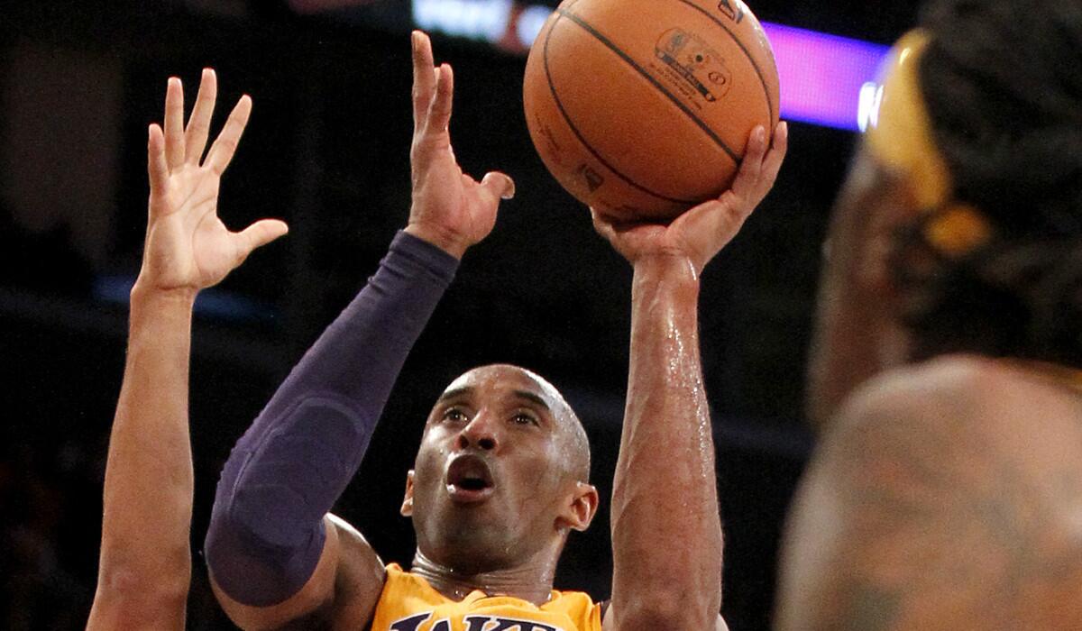 Lakers guard Kobe Bryant puts up a left-handed shot against the Spurs in the fourth quarter Friday night at Staples Center.