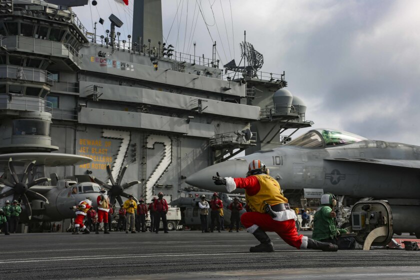 SOUTH CHINA SEA (Dec. 24, 2019) A Sailor dressed as Santa Claus directs the launch of an F/A-18E Super Hornet on the flight deck of the aircraft carrier USS Abraham Lincoln (CVN 72). The Lincoln is due to arrive in San Diego in early 2020 after a round-the-world deployment of more than nine months.