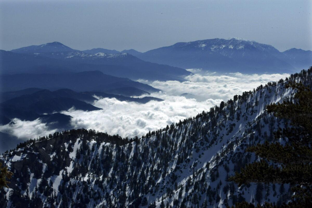 In this file photo, the clouds come up the valley to meet Mt. Baldy. Daniel Nguyen, a recent Cal State Long Beach graduate, fell 1,500 feet to his death Tuesday while trying to help a fellow hiker on Mt. Baldy.