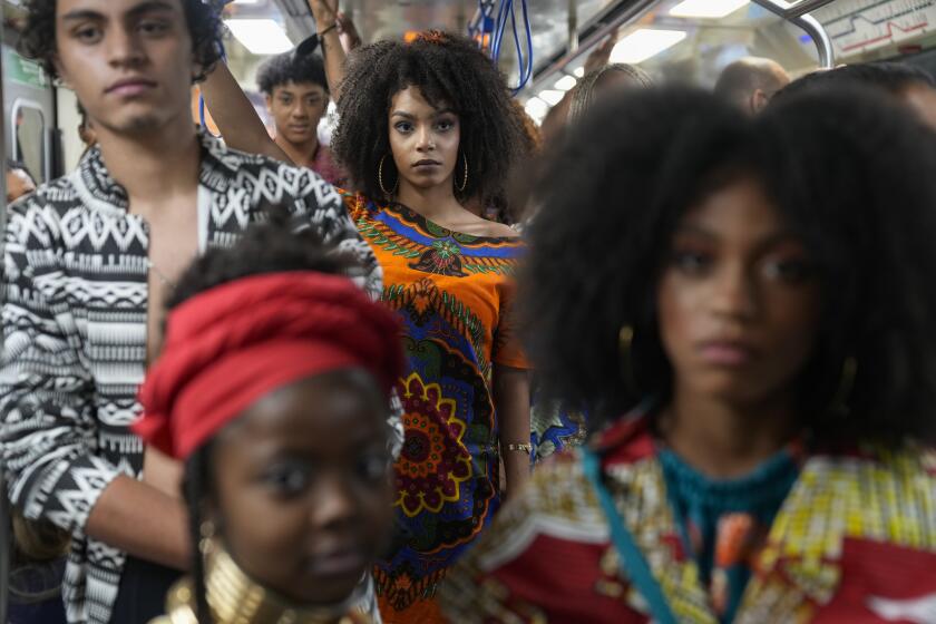 ARCHIVO - Modelos llevan prendas diseñadas por estudiantes de comunidades afrobrasileñas en una estación de metro como parte del Mes de Conciencia negra en Sao paulo, el 19 de noviembre de 2021. En Brasil, más de la mitad de la población se identifica como negra o birracial, (AP Foto/Andre Penner, Archivo)