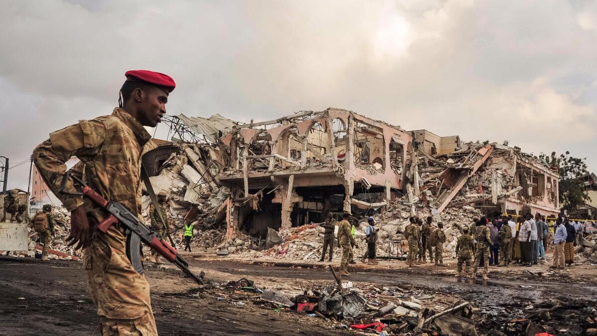 Somali soldiers patrol the scene of the truck bombing in Mogadishu.