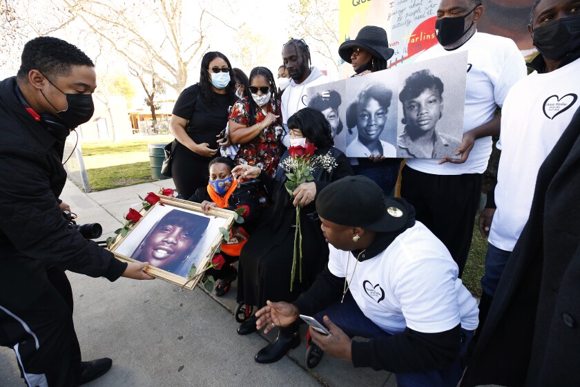 Filmmaker Shannon Dion, left, places a portrait of Latasha Harlin.