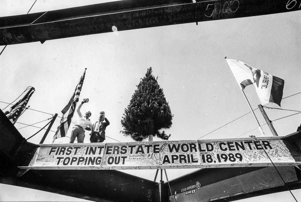 April 18, 1989: Two visitors wave during topping-off ceremonies for the 73-story Library Tower, also named the First Interstate World Center, in downtown Los Angeles.