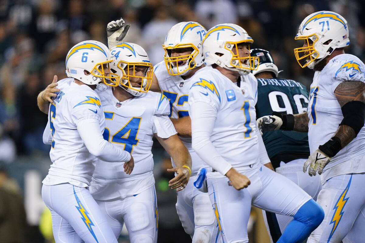 Chargers' Dustin Hopkins celebrates his game-winning field goal against the Eagles with teammates.