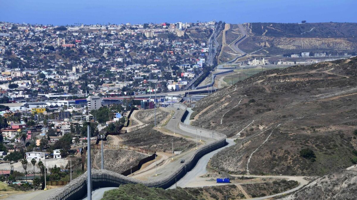 Construction to replace the shorter, brown barrier closer to Tijuana began Friday along a 14-mile stretch of the San Diego border. Congress has funded projects to replace both rows of fencing in this part of the U.S.-Mexico border.