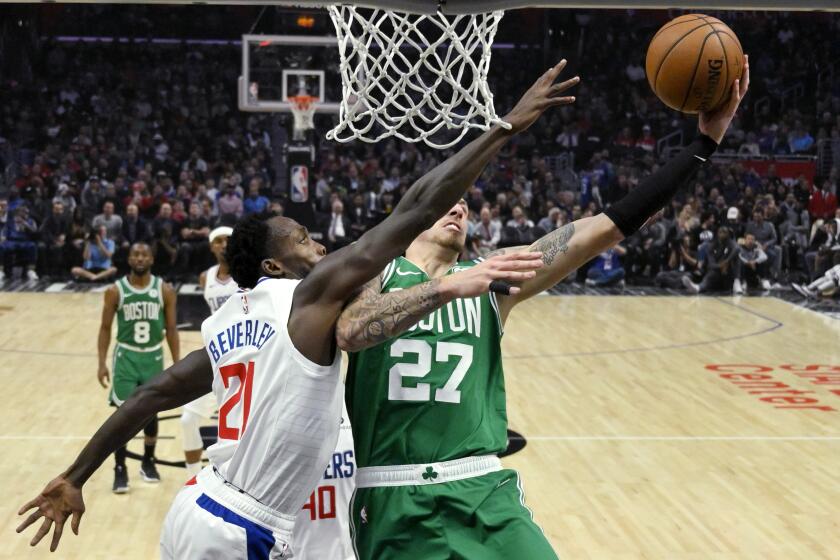 Boston Celtics forward Daniel Theis, right, shoots as Los Angeles Clippers guard Patrick Beverley defends during the second half of an NBA basketball game Wednesday, Nov. 20, 2019, in Los Angeles. (AP Photo/Mark J. Terrill)