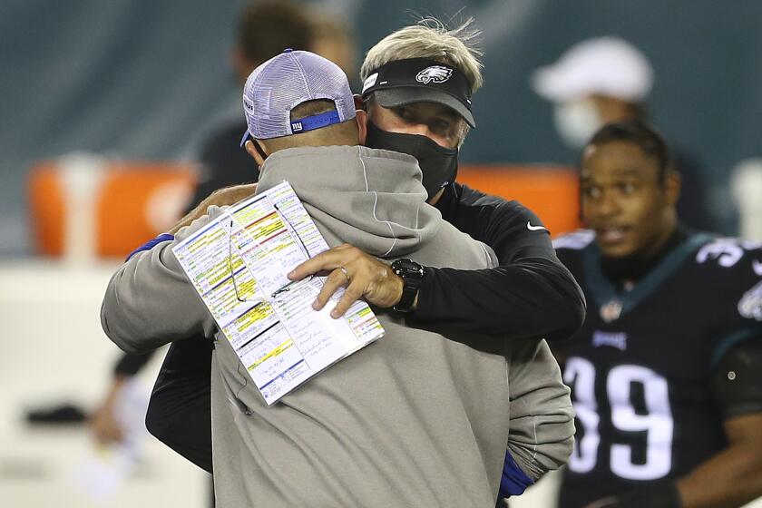 New York Giants' head coach Joe Judge hugs Philadelphia Eagles head coach Doug Pederson 