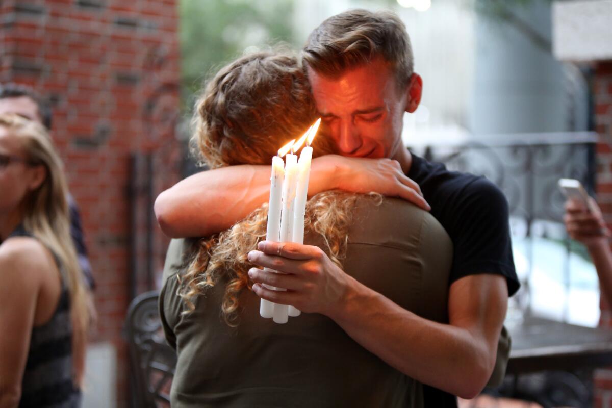 Brett Morian, de Daytona Beach, abraza a otro asistente a una vigilia en Ember por las 50 víctimas mortales de una balacera en un club nocturno gay de Orlando, el 12 de junio de 2016. (Joshua Lim/Orlando Sentinel via AP)