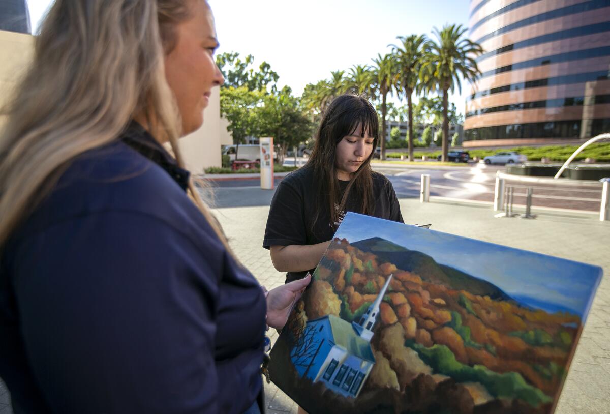 City employee Caitlin Weigler checks in Celeste Nevarez's art work Thursday at Segerstrom's Samueli Theater.