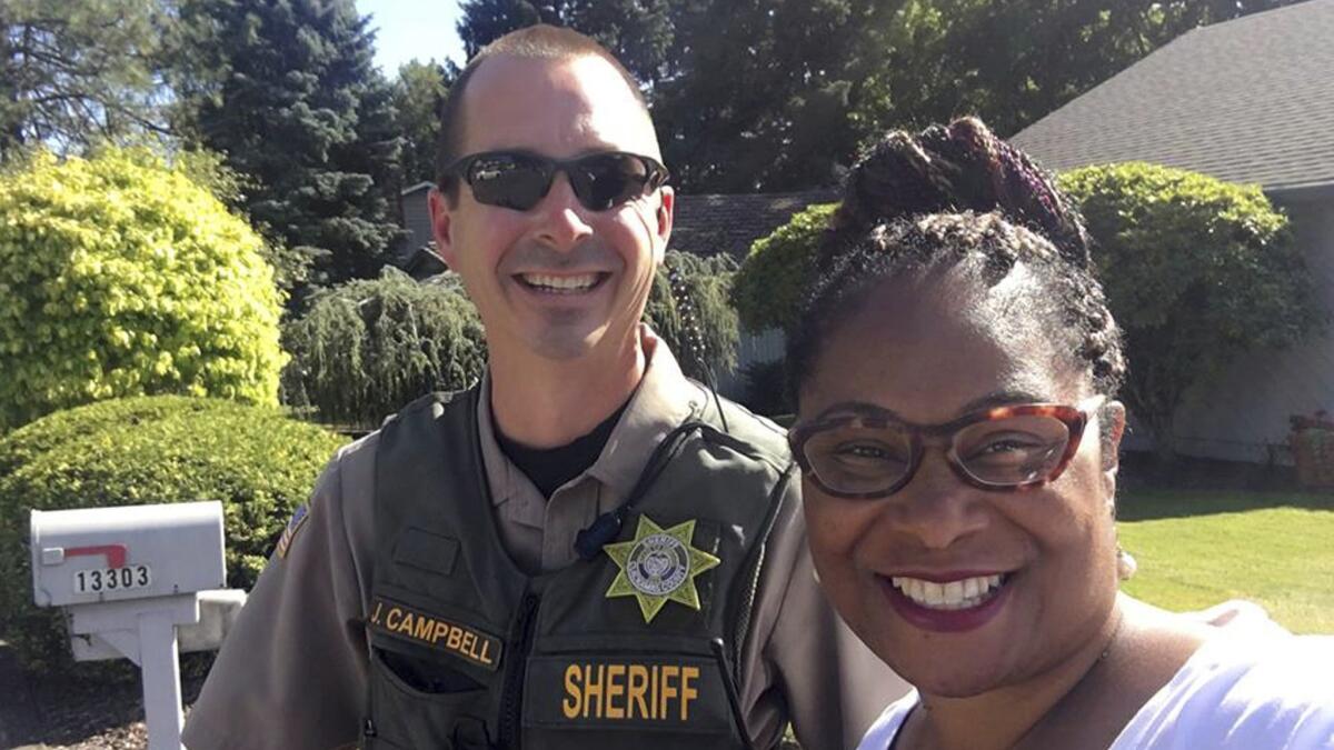 Oregon state Rep. Janelle Bynum, poses with a Clackamas County Sheriff's officer after he stopped her in Clackamas, Ore. on Tuesday.