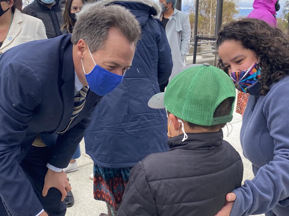 Montana Gov. Steve Bullock, a Democrat running for U.S. Senate, meets Archer James, 6, as his mother, Lisa, looks on.