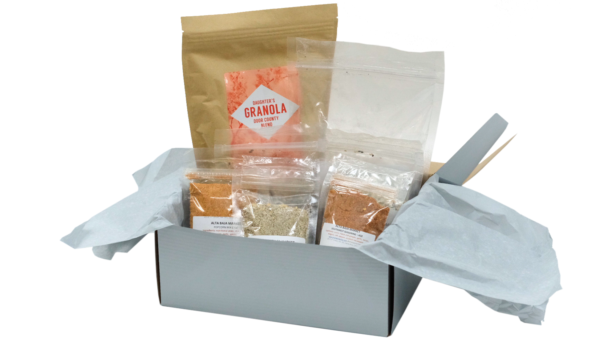 A pantry box by Alta Baja containing packets of granola and spices