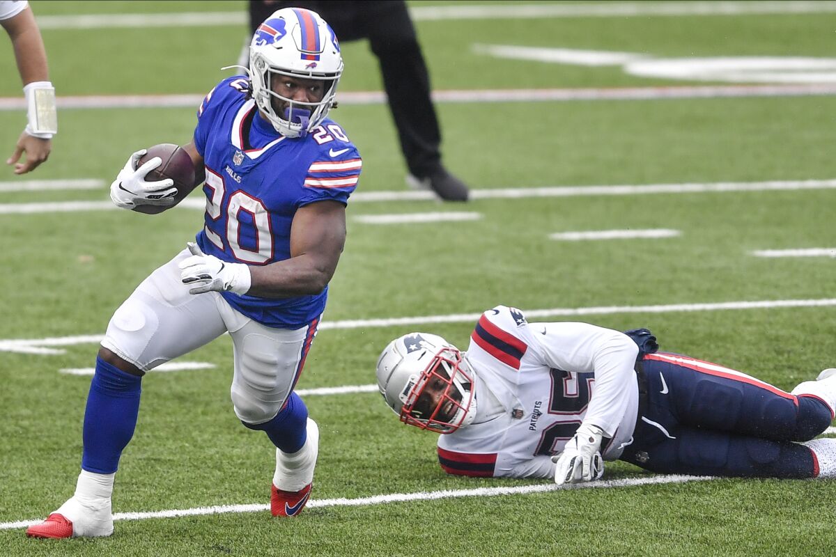 Buffalo Bills' Zack Moss (20) rushes past New England Patriots' Terrence Brooks (25) during the first half of an NFL football game Sunday, Nov. 1, 2020, in Orchard Park, N.Y. (AP Photo/Adrian Kraus)