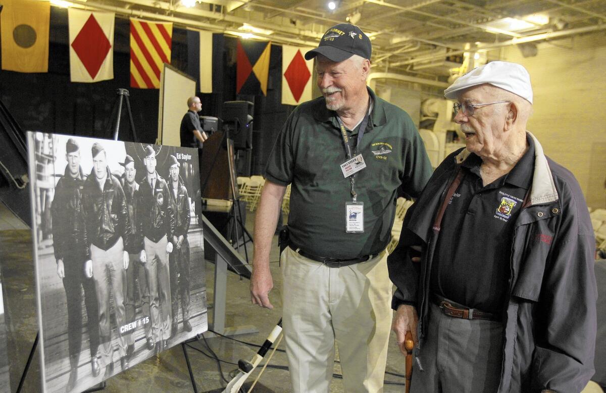 Edward Saylor, right, talks with USS Hornet volunteer Roger Felton as they look at an old photograph in Alameda, Calif., on May 5, 2012.