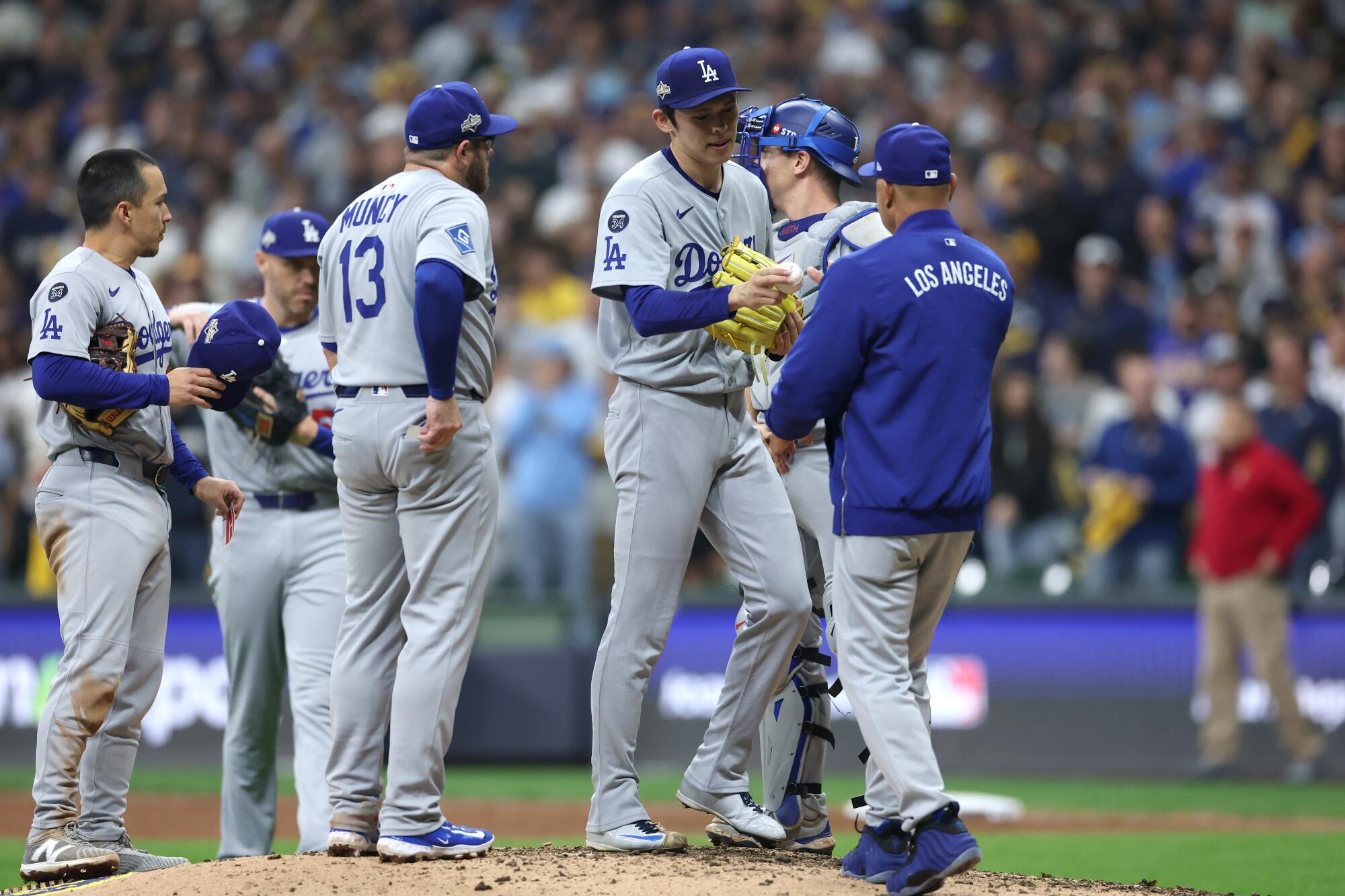 Dodgers manager Dave Roberts removes reliever Roki Sasaki from the game in the ninth inning.