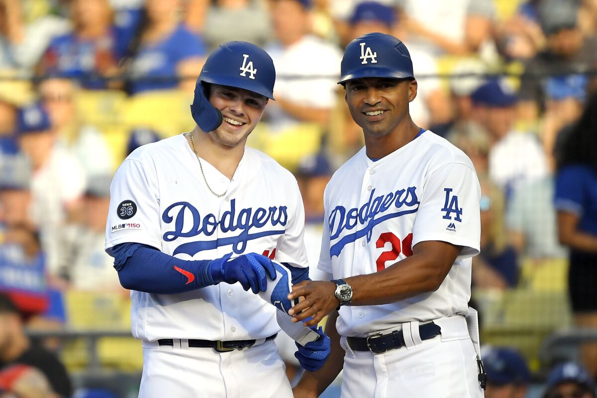 Dodgers first base coach George Lombard, right, stands next to Gavin Lux during a game in September 2019.