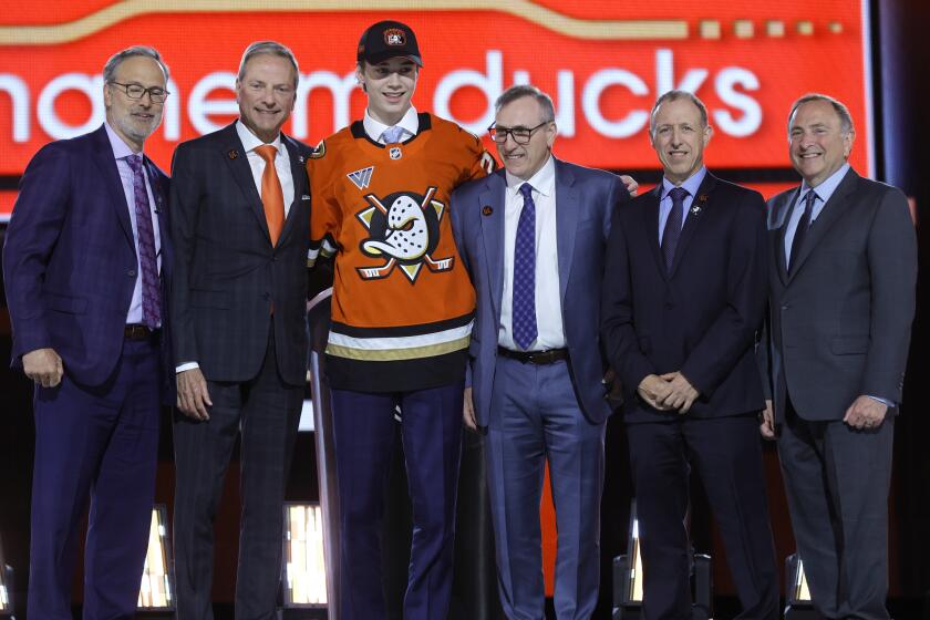 Beckett Sennecke, center left, poses after being selected by the Anaheim Ducks.