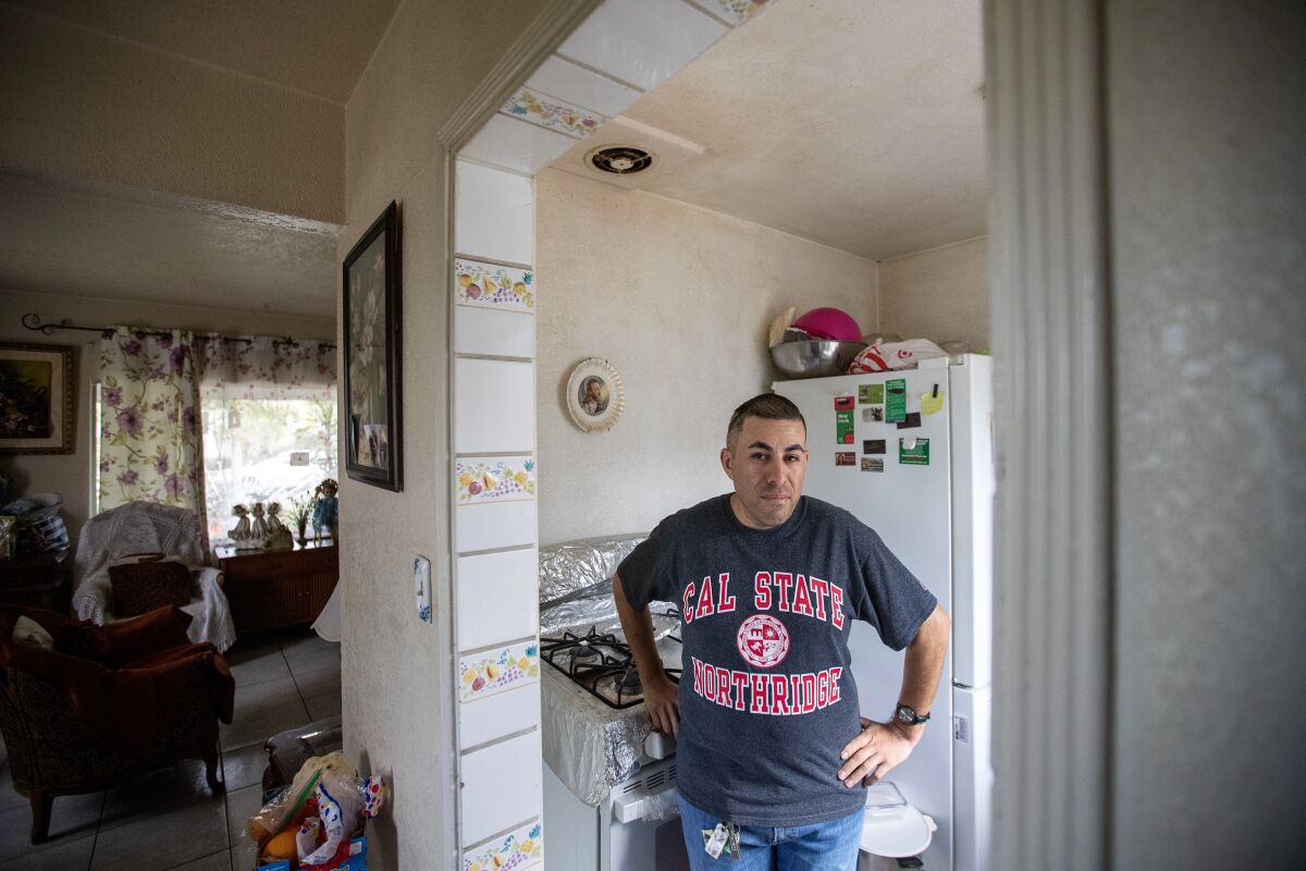 Lionel Mares stands in the kitchen of his home in Los Angeles. Mares gas bill has doubled from last winter.